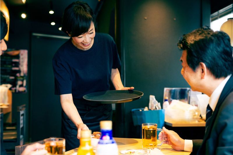 料理を運ぶ女性スタッフ